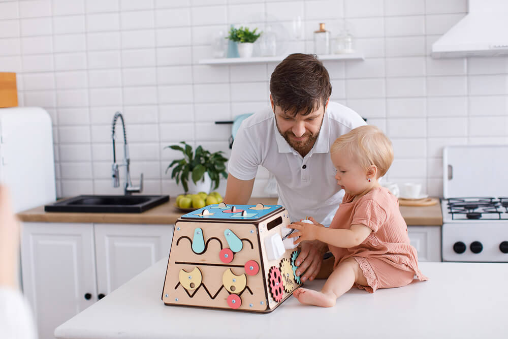 Una bambina scopre un giocattolo di legno insieme al padre.